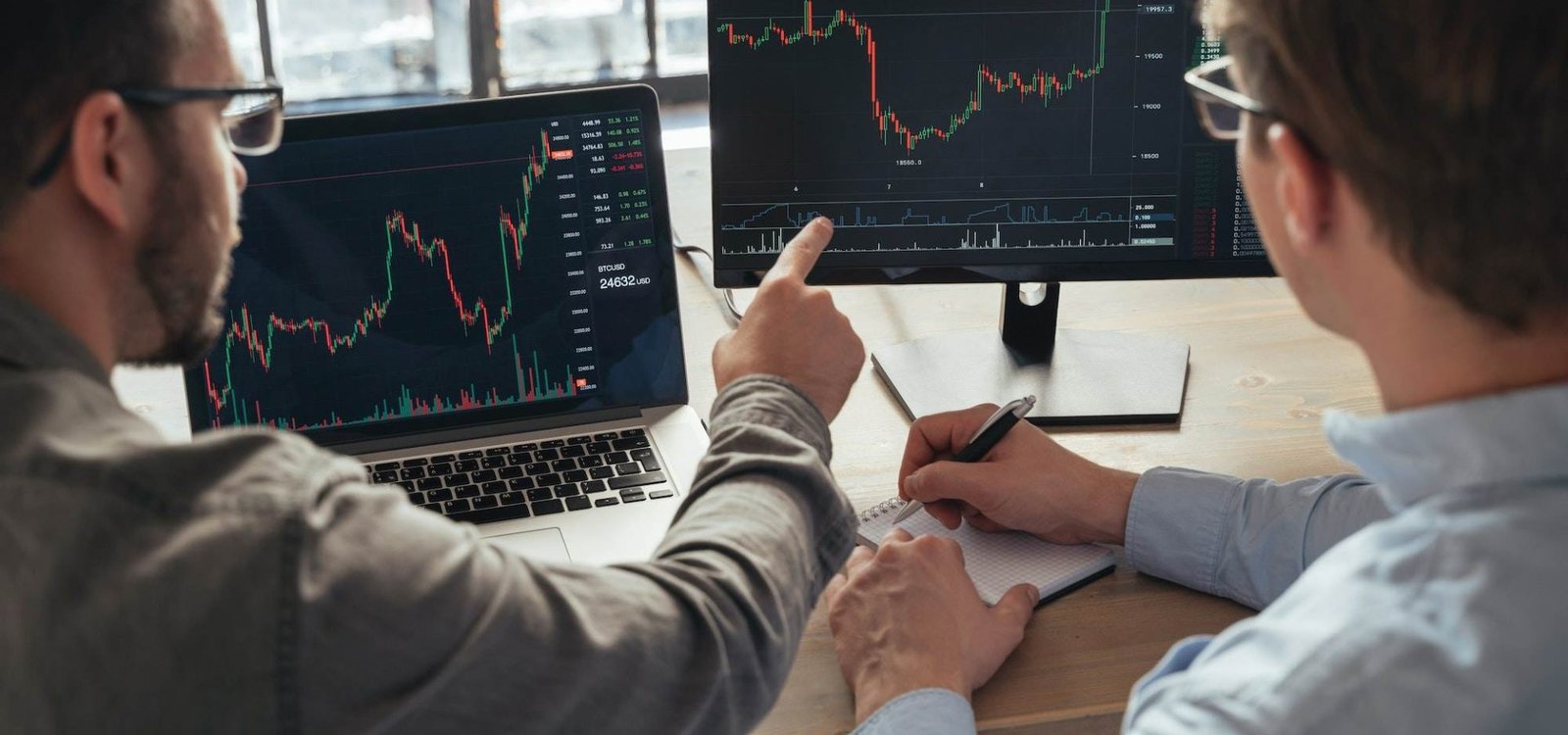 crypto-traders-sitting-together-in-front-of-pcs-monitoring-candlestick-charts.jpg
